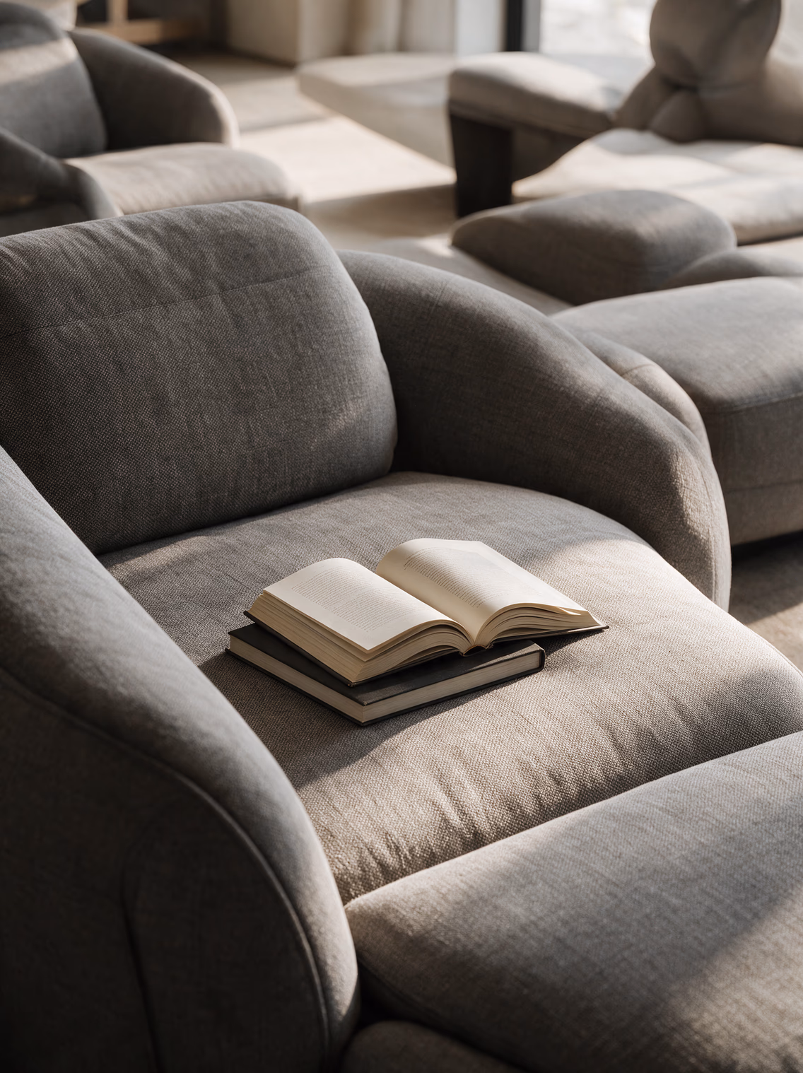 Light grey sofa with an open book resting on the cushion
