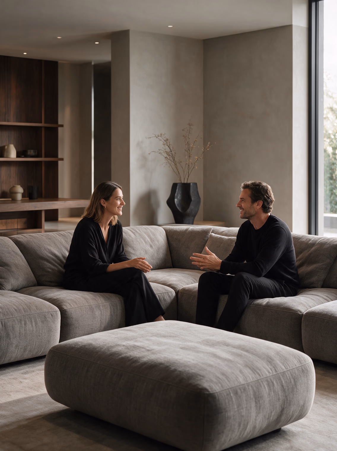 Two people talking on a light sofa